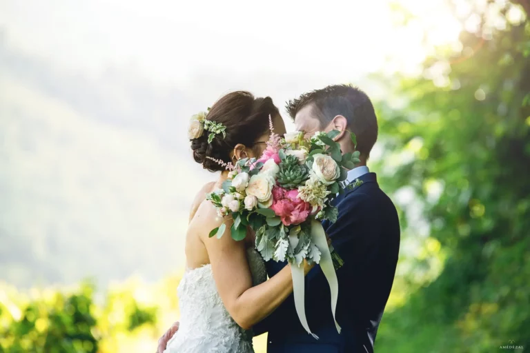 Les mariés se cachent derrière le bouquet pour s'embrasser au Domaine de Vavril Reportage photos par Amédézal