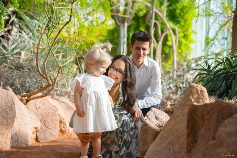 Famille souriante posant dans une serre tropicale entourée de cactus et de végétation luxuriante, séance photo lifestyle par Amedezal près de Lyon